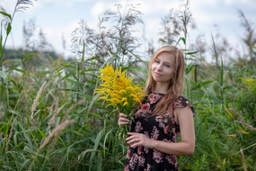 手持黄色野花束的美女图片